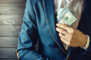 person putting cash inside his blazer